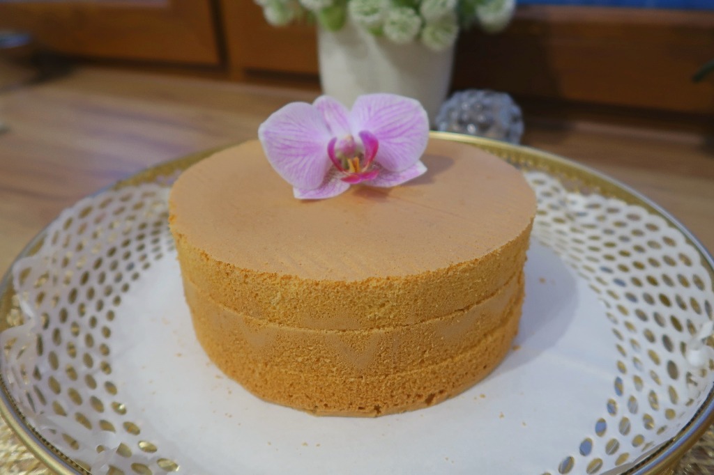 Biszkopt na złotym talerzu z orchideą – widok z góry